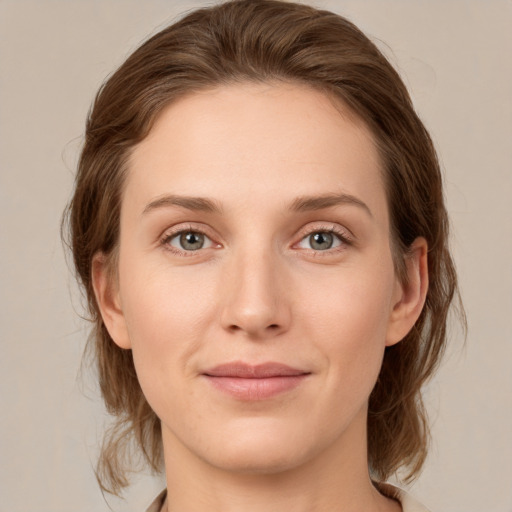 Joyful white young-adult female with medium  brown hair and green eyes