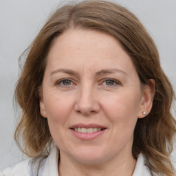 Joyful white adult female with medium  brown hair and grey eyes