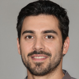 Joyful white young-adult male with short  black hair and brown eyes