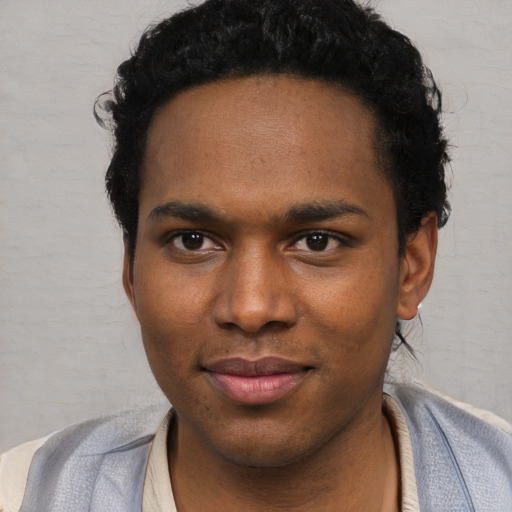 Joyful black young-adult male with short  black hair and brown eyes