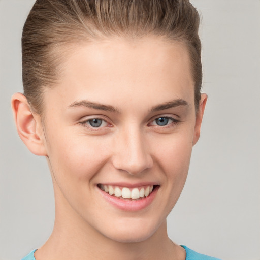 Joyful white young-adult female with short  brown hair and grey eyes