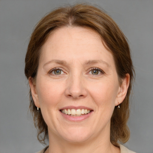 Joyful white adult female with medium  brown hair and grey eyes