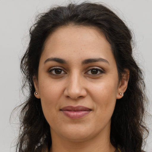 Joyful latino adult female with long  brown hair and brown eyes
