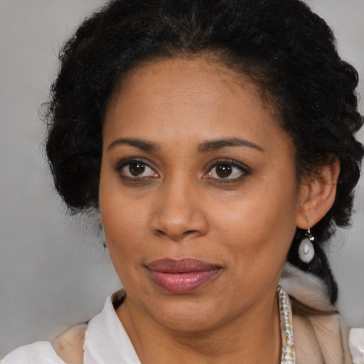 Joyful black adult female with medium  brown hair and brown eyes