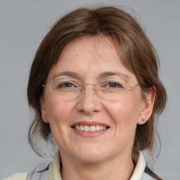 Joyful white adult female with medium  brown hair and blue eyes