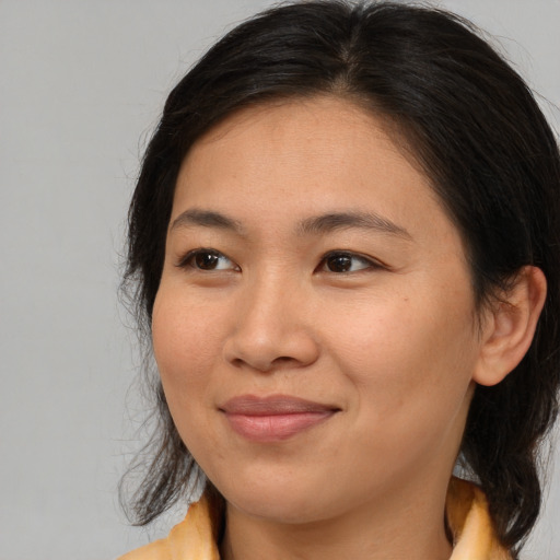 Joyful asian young-adult female with medium  brown hair and brown eyes