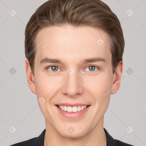 Joyful white young-adult male with short  brown hair and grey eyes