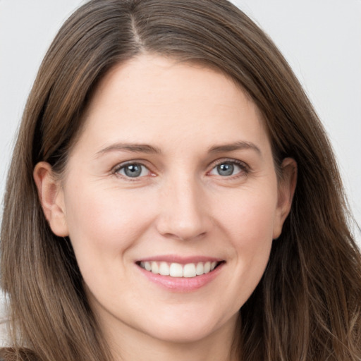 Joyful white young-adult female with long  brown hair and grey eyes