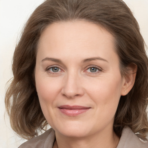 Joyful white adult female with medium  brown hair and grey eyes