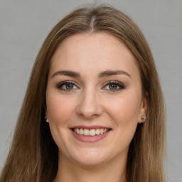 Joyful white young-adult female with long  brown hair and green eyes