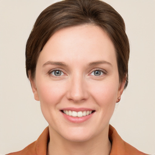 Joyful white young-adult female with short  brown hair and grey eyes