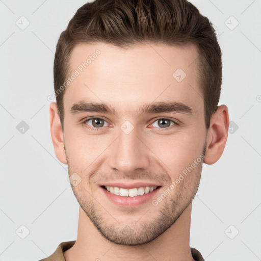 Joyful white young-adult male with short  brown hair and grey eyes