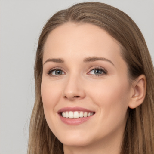 Joyful white young-adult female with long  brown hair and grey eyes