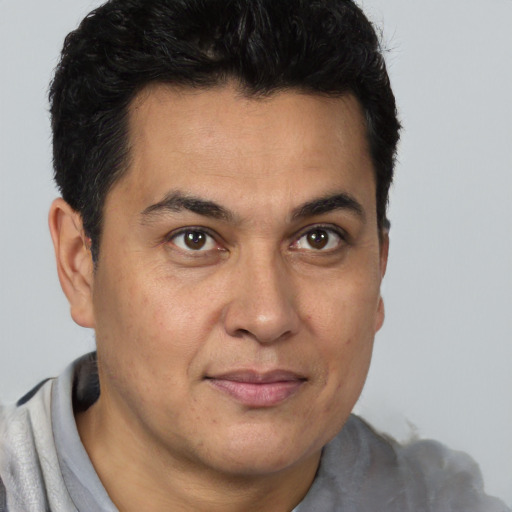 Joyful latino adult male with short  brown hair and brown eyes