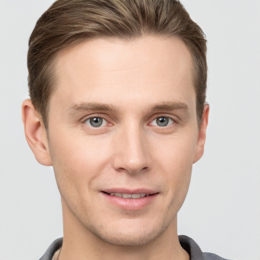 Joyful white young-adult male with short  brown hair and grey eyes