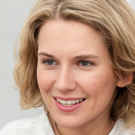 Joyful white young-adult female with medium  brown hair and blue eyes