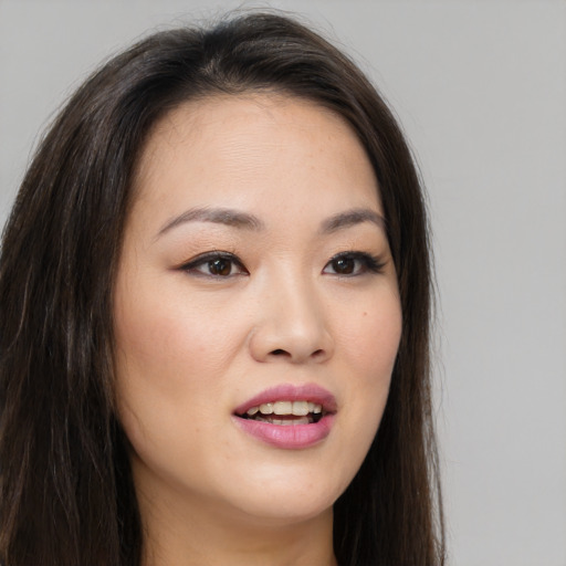 Joyful asian young-adult female with long  brown hair and brown eyes