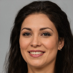 Joyful white adult female with long  brown hair and brown eyes