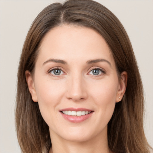 Joyful white young-adult female with long  brown hair and grey eyes