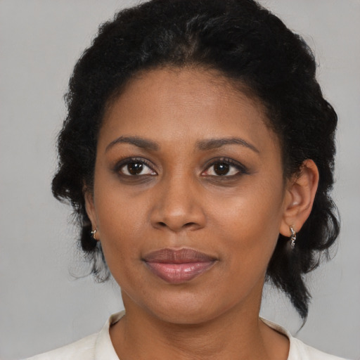 Joyful black adult female with medium  brown hair and brown eyes