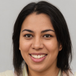 Joyful latino young-adult female with medium  brown hair and brown eyes