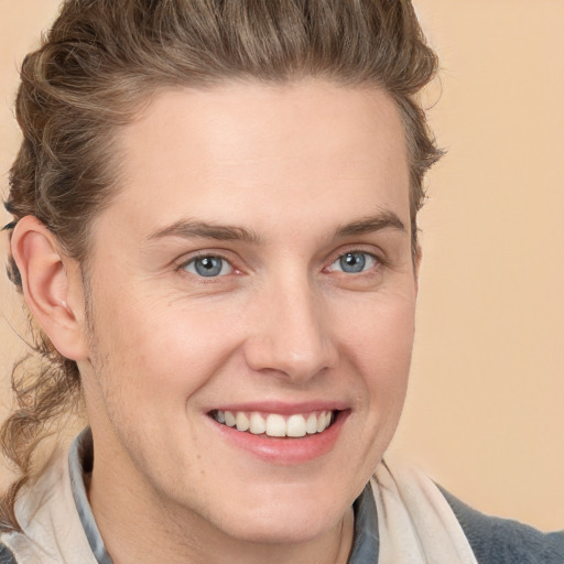 Joyful white young-adult male with medium  brown hair and blue eyes