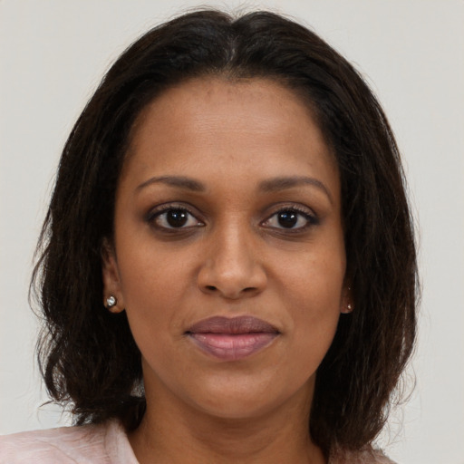 Joyful black young-adult female with medium  brown hair and brown eyes