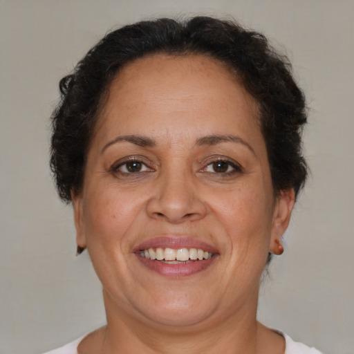 Joyful latino adult female with short  brown hair and brown eyes