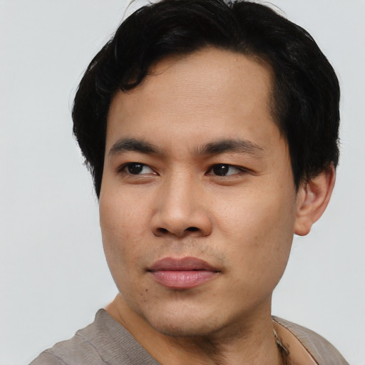 Joyful asian young-adult male with short  black hair and brown eyes