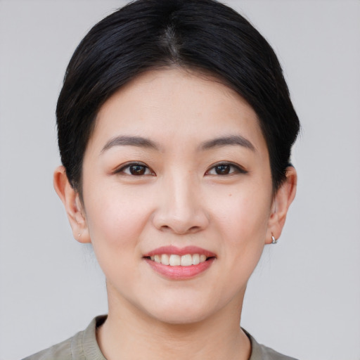 Joyful asian young-adult female with short  black hair and brown eyes