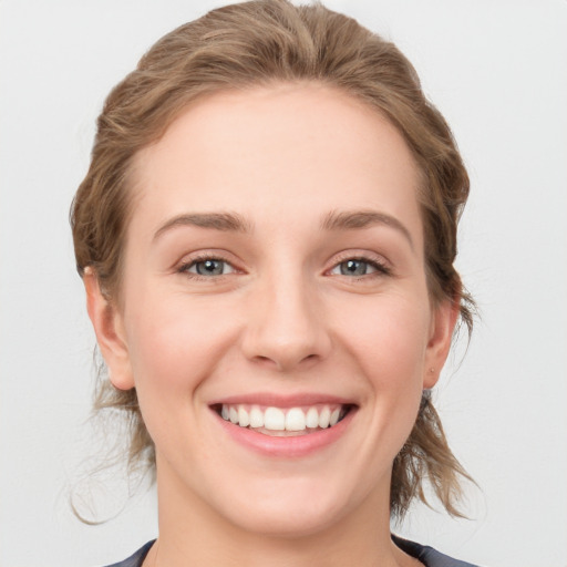 Joyful white young-adult female with medium  brown hair and blue eyes