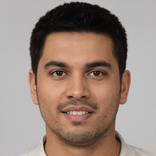 Joyful latino young-adult male with short  black hair and brown eyes