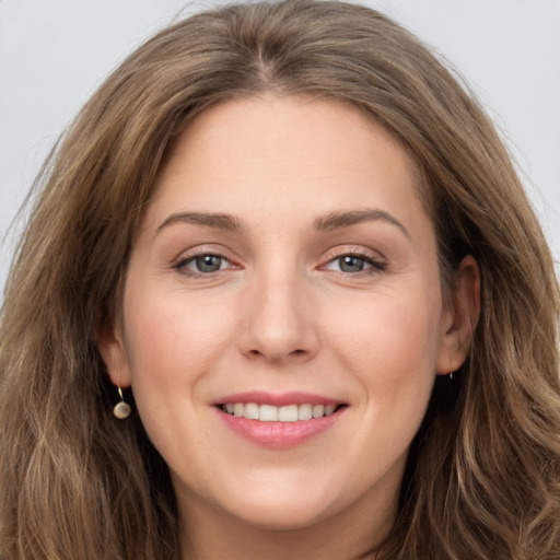 Joyful white young-adult female with long  brown hair and brown eyes