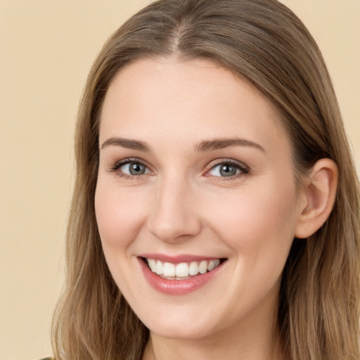 Joyful white young-adult female with long  brown hair and brown eyes