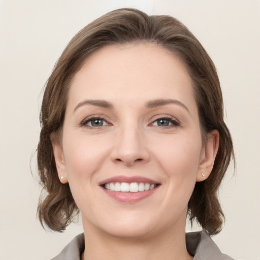 Joyful white young-adult female with medium  brown hair and grey eyes