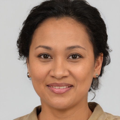 Joyful latino adult female with medium  brown hair and brown eyes