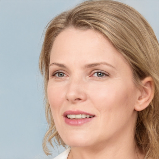 Joyful white adult female with long  brown hair and blue eyes