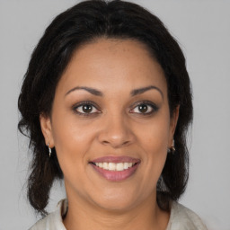 Joyful black adult female with medium  brown hair and brown eyes