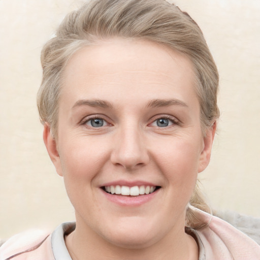 Joyful white young-adult female with short  brown hair and blue eyes