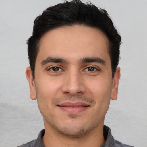 Joyful white young-adult male with short  black hair and brown eyes