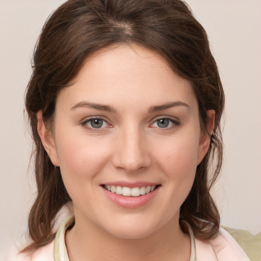 Joyful white young-adult female with medium  brown hair and grey eyes