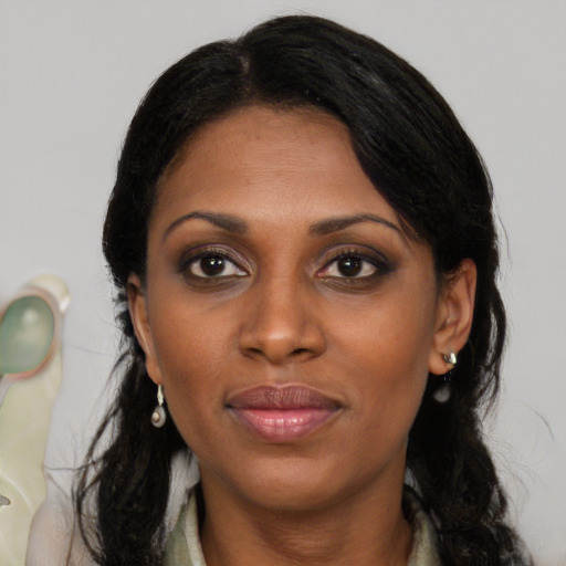 Joyful black young-adult female with long  black hair and brown eyes