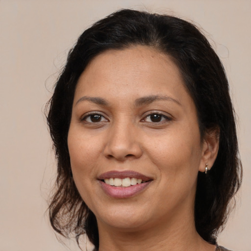 Joyful latino adult female with medium  brown hair and brown eyes