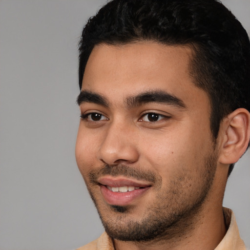 Joyful latino young-adult male with short  black hair and brown eyes