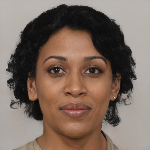 Joyful black adult female with short  black hair and brown eyes