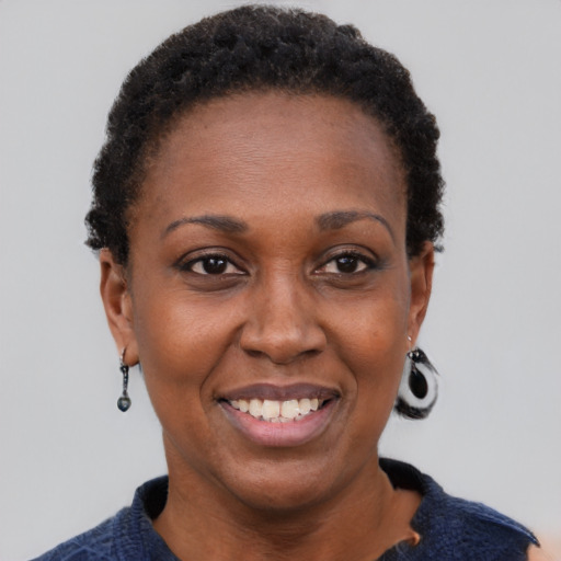 Joyful black adult female with short  brown hair and brown eyes