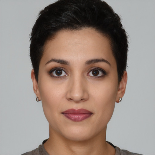 Joyful latino young-adult female with short  black hair and brown eyes