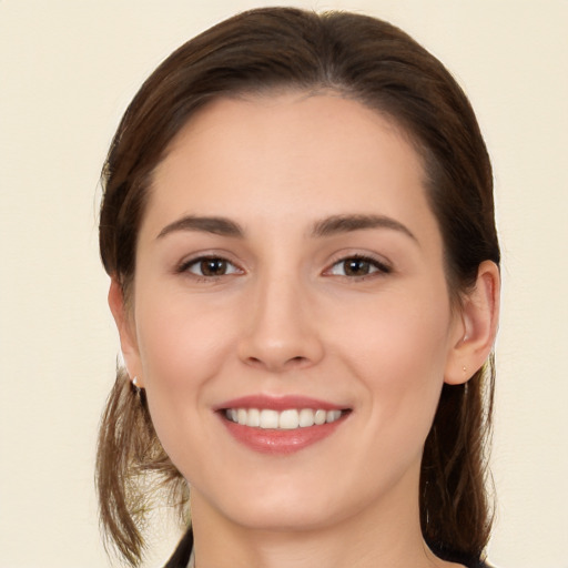 Joyful white young-adult female with long  brown hair and brown eyes