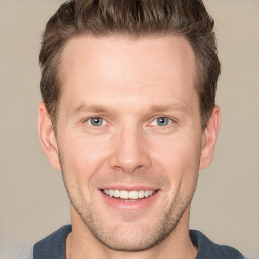 Joyful white young-adult male with short  brown hair and grey eyes