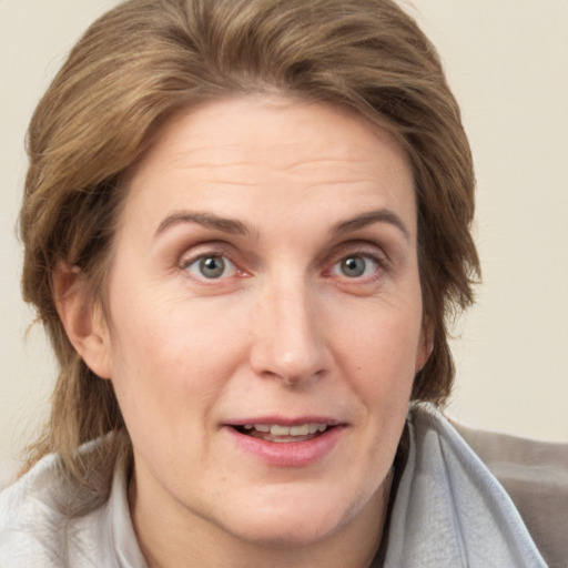 Joyful white adult female with medium  brown hair and brown eyes